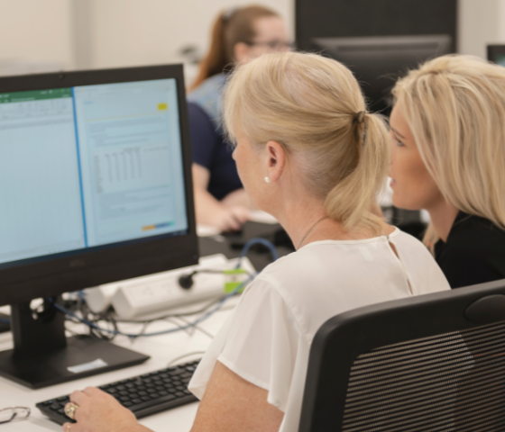 accounting student working at computer with lecturer 