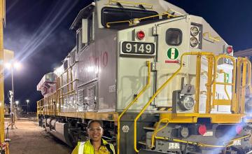 Electrical Apprentice, Geraiyah Wiggan standing in front of a Rio Tinto locomotove.